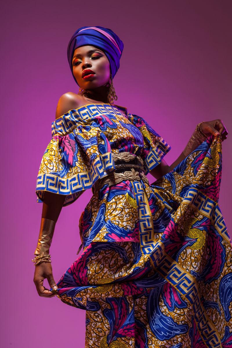 紫色背景下穿服装跳舞的非洲美女