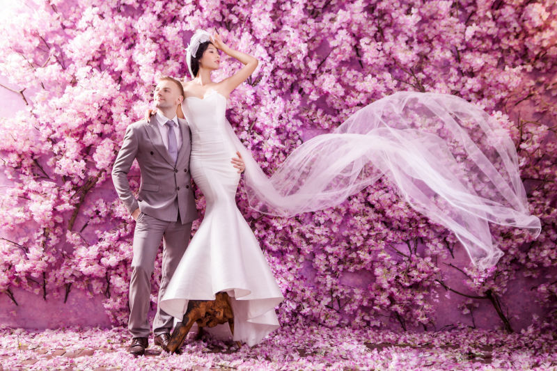 一对在紫色花朵下拍摄结婚照