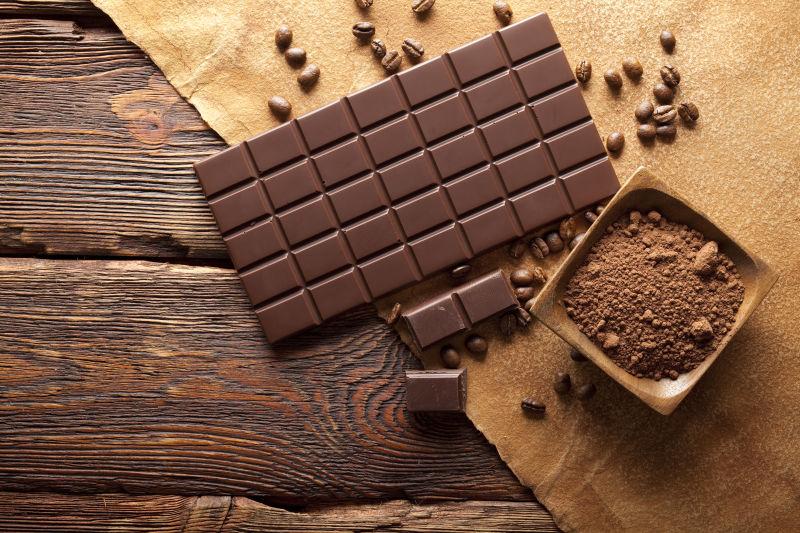 木桌上的黑色巧克力和巧克力粉