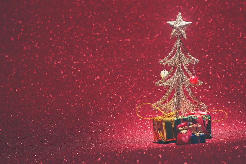 红色背景下的金色圣诞树与礼物