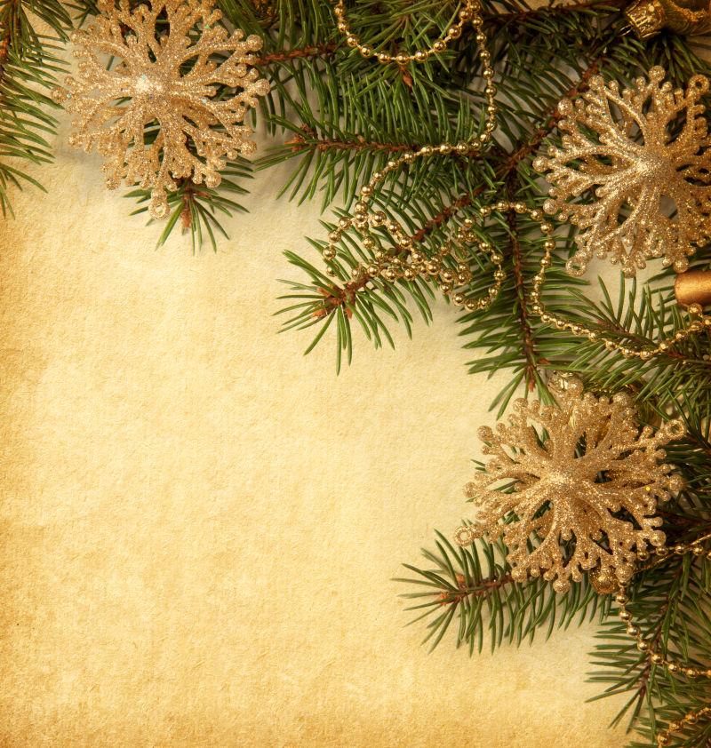 旧羊皮纸上的美丽的树枝和金色圣诞雪花饰品
