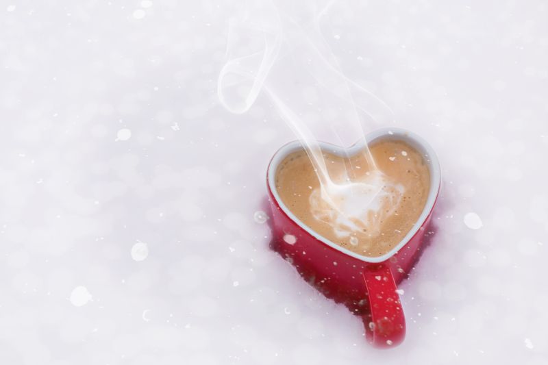 红色心形咖啡杯里的咖啡冒着热气