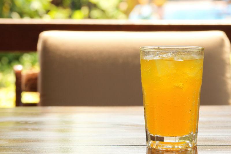 桌子上的一杯冰橙汁