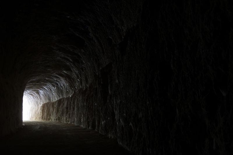 黑暗的岩石隧道和出口的光