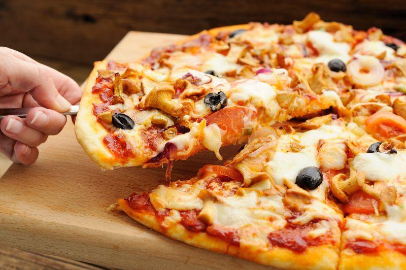 拿起一片木桌上美味的披萨