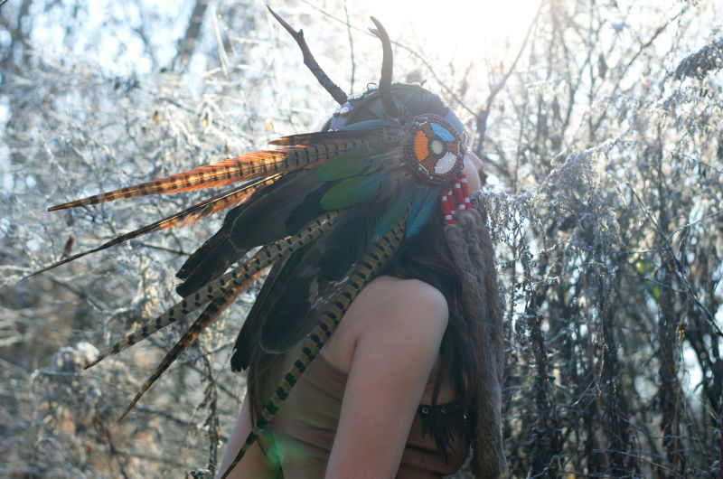 森林中戴着羽毛帽子的女人