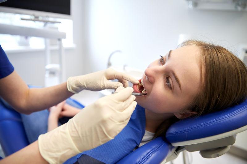 牙医使用镜片为病人检查牙齿
