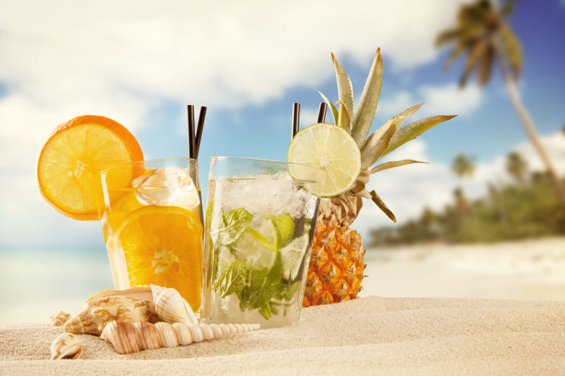 放在沙滩上的水果饮料