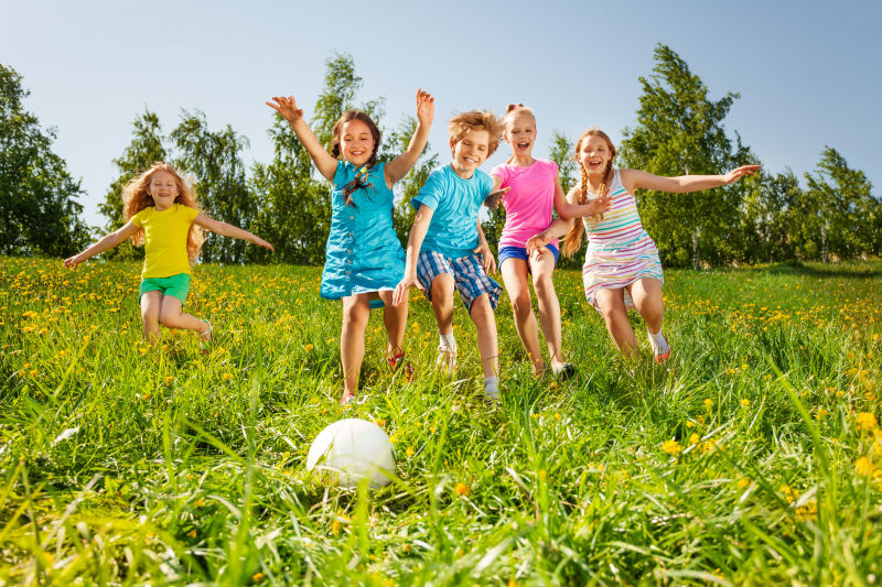 快乐儿童在草地上玩足球