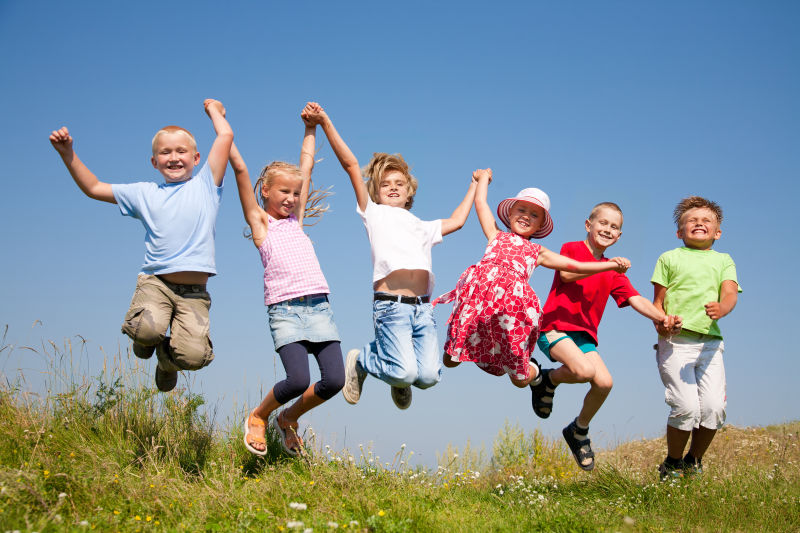 快乐的孩子们在草地上跳跃