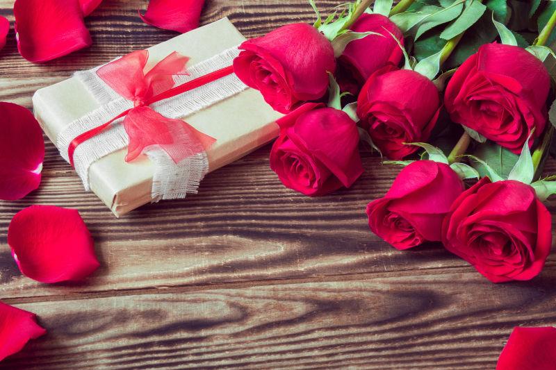 木桌上的礼物盒和玫瑰花