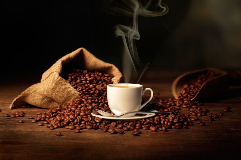 一杯热气腾腾的咖啡与咖啡豆