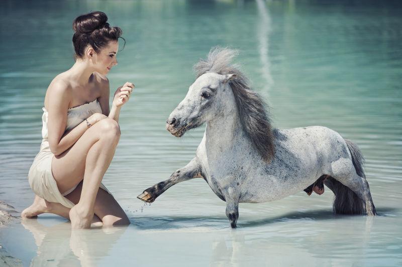 女人在水中与马嬉戏