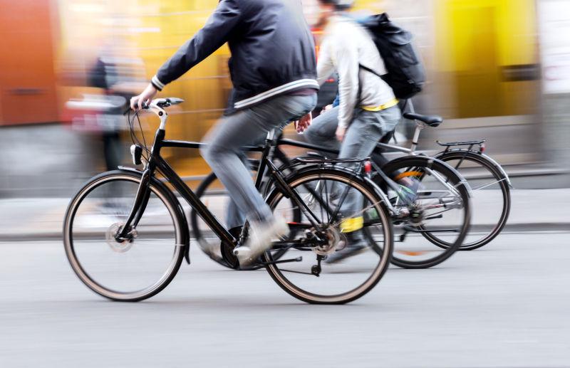 在城市街头骑自行车的三个人