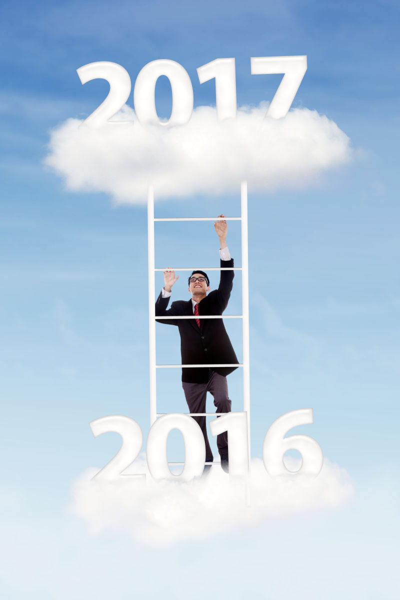 年轻的商人在云天向上爬上从云数2016到2017号的梯子
