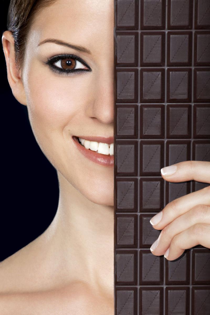 年轻美女拿着一块巧克力