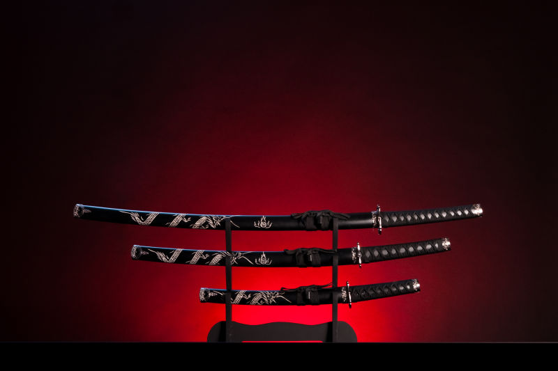 黑暗红色灯光下的三把日本刀剑