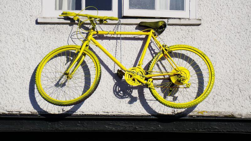 挂在窗户上的黄色自行车