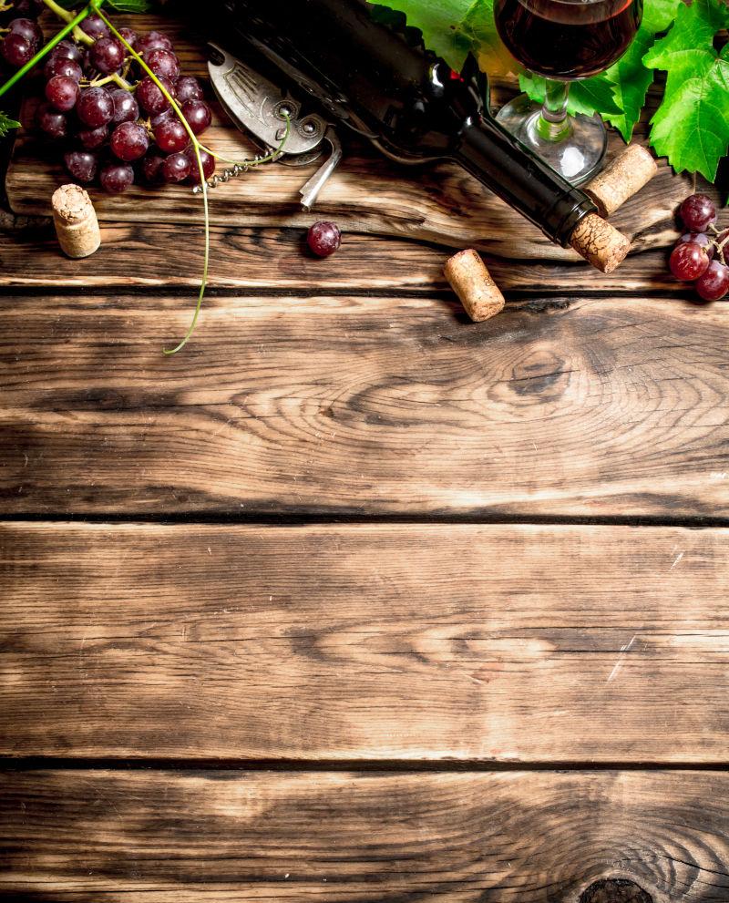 木桌上的红葡萄酒和葡萄