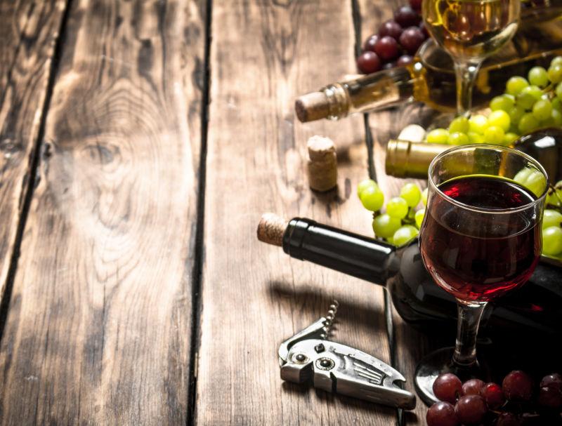 木桌上的红葡萄酒和白葡萄
