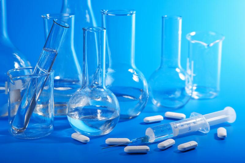 实验室里蓝色桌上的的玻璃器皿和药片等