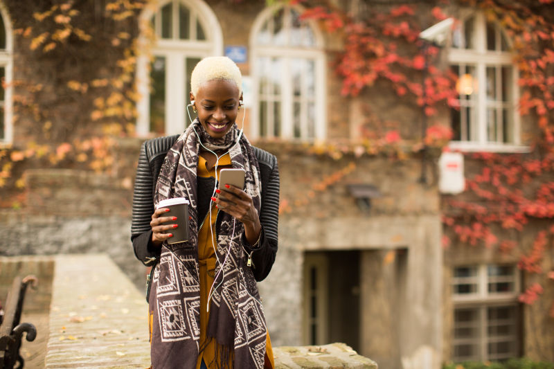 时尚的黑人女孩 拿着手机和咖啡