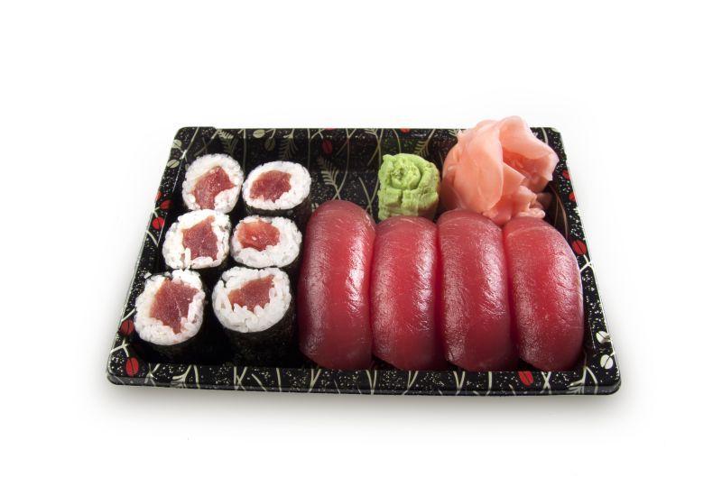白色背景下黑色盘子里的寿司和金枪鱼美食