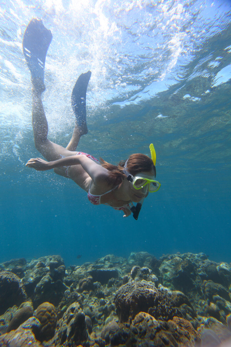 海底观察礁石的美女潜水员