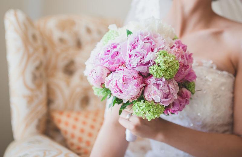 坐在沙发上的新娘手中的手捧花