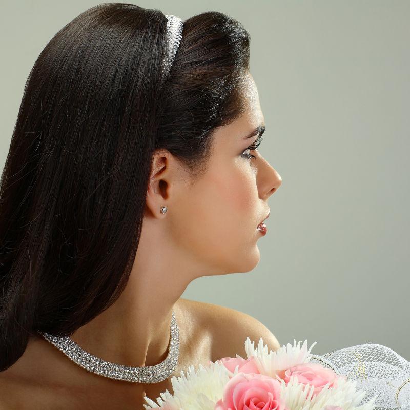 捧着美丽花束的新娘带着珠宝装饰