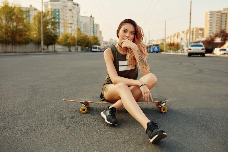 大街上坐在滑板上的美女