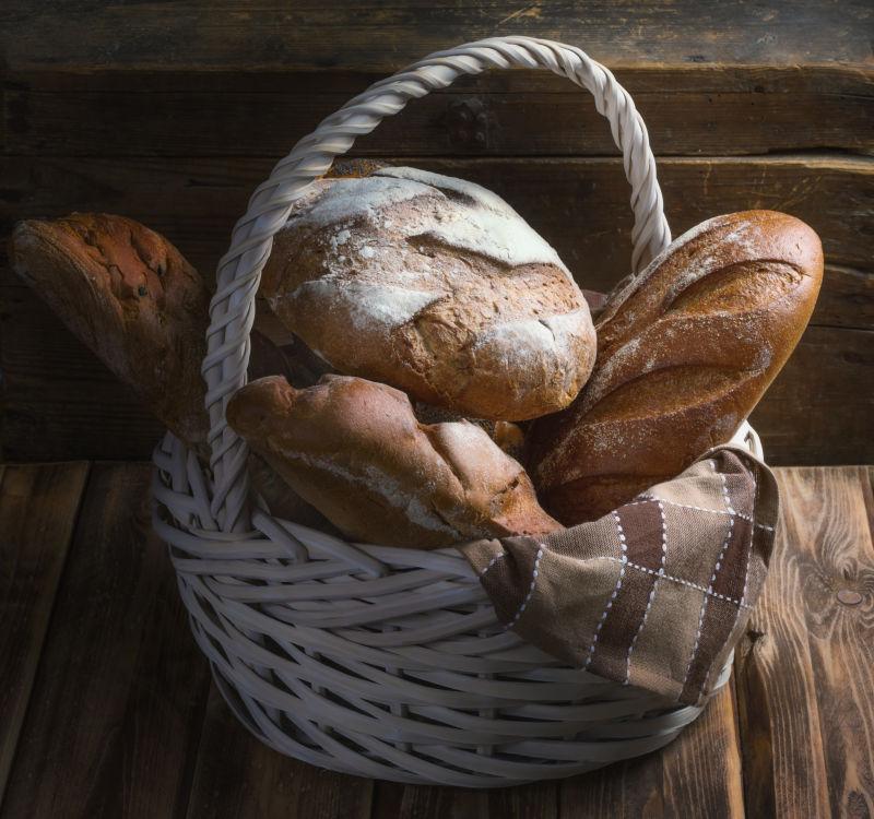 木桌上的篮子里放着美味的面包