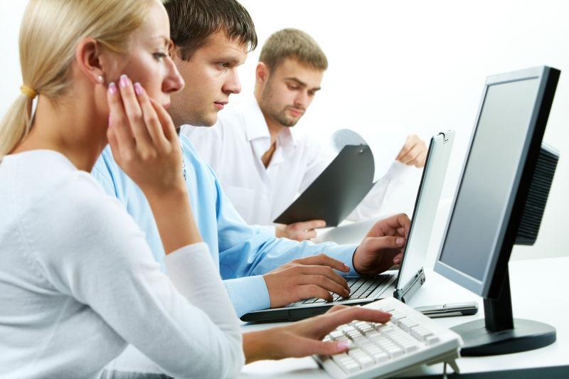 白色背景下使用笔记本电脑工作的团队