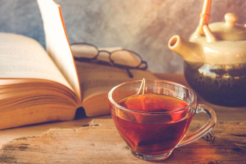 木桌上书眼镜和一杯红茶
