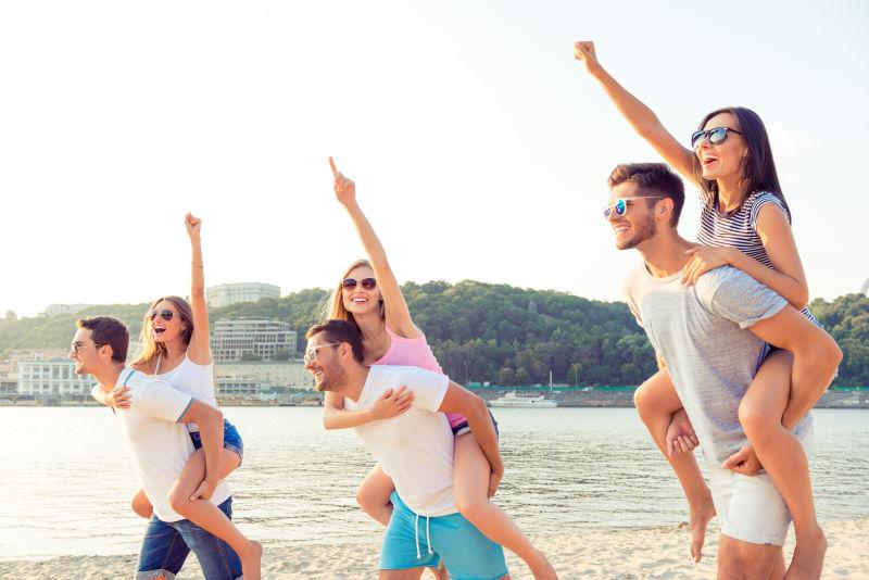 一群快乐的年轻人在海滩上度过快乐的夏日