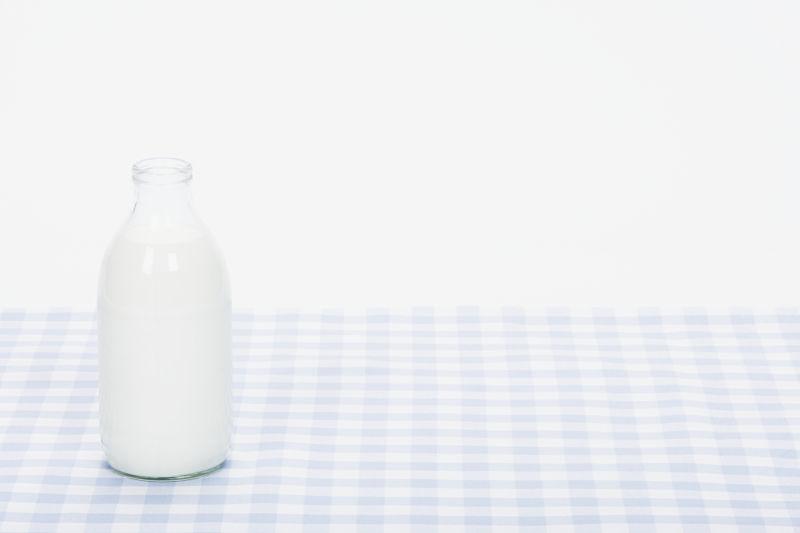 格子布桌面的一瓶牛奶