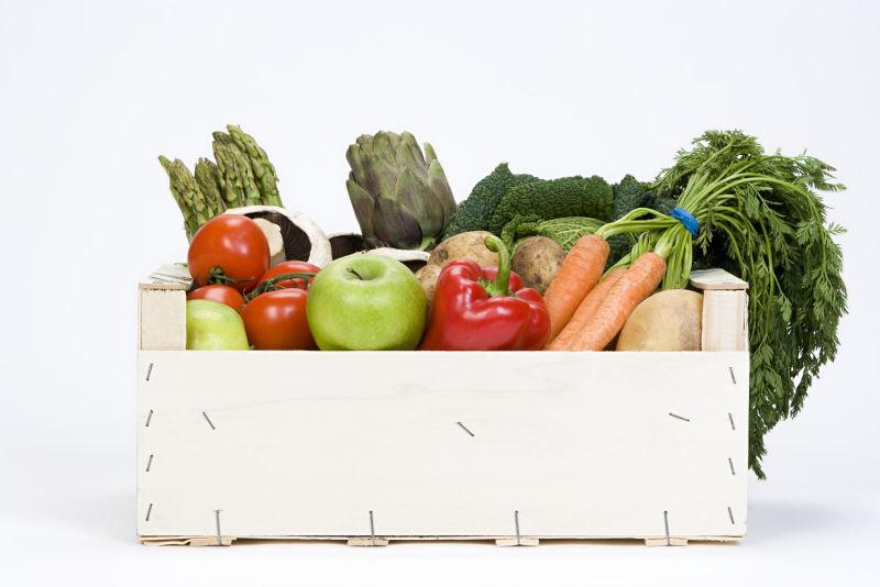 白色背景上的盒子里放满了各种绿色蔬菜食材