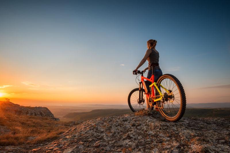 夕阳下在山顶的山地自行车骑士