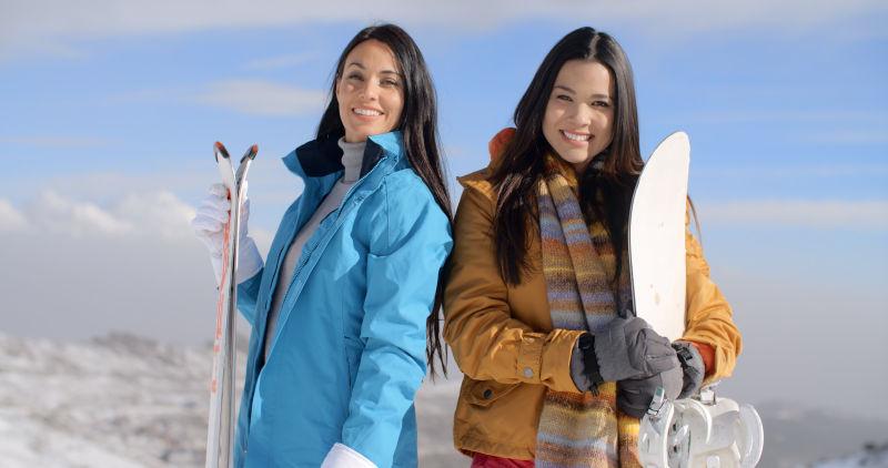 两个漂亮滑雪女孩在雪山山顶上