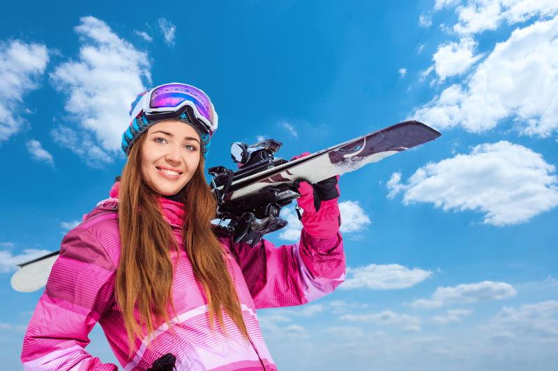 户外蓝天白云下的微笑滑雪美女