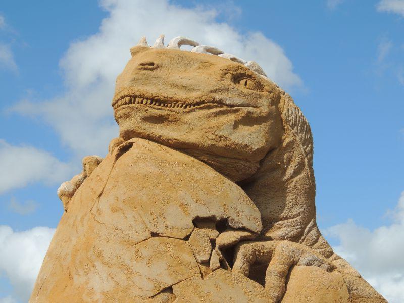 蓝天下壮观的恐龙沙子雕像