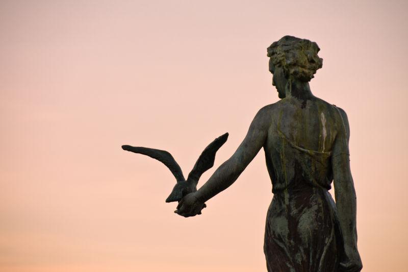 夕阳下美丽的少女海鸥雕像