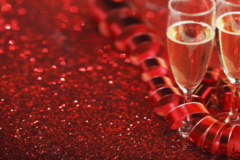 香槟酒杯和红光闪闪的礼物