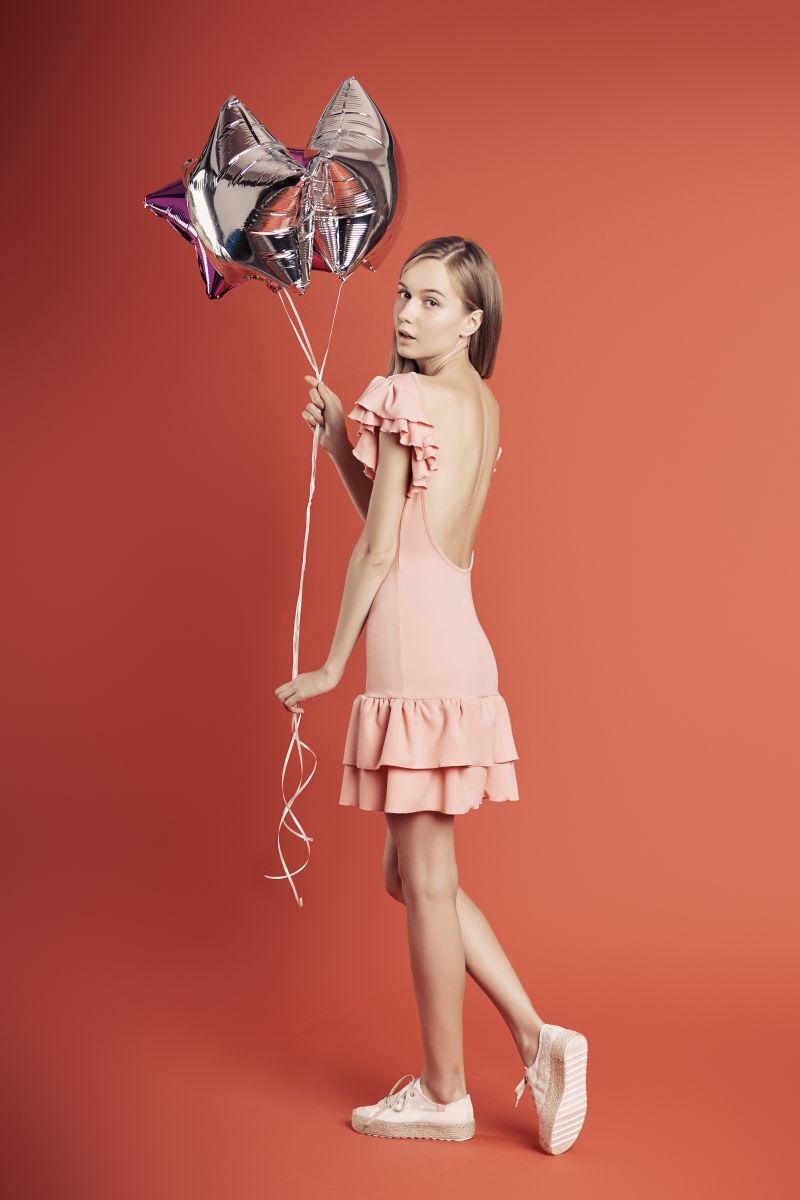 粉色裙子年轻美女拿着气球