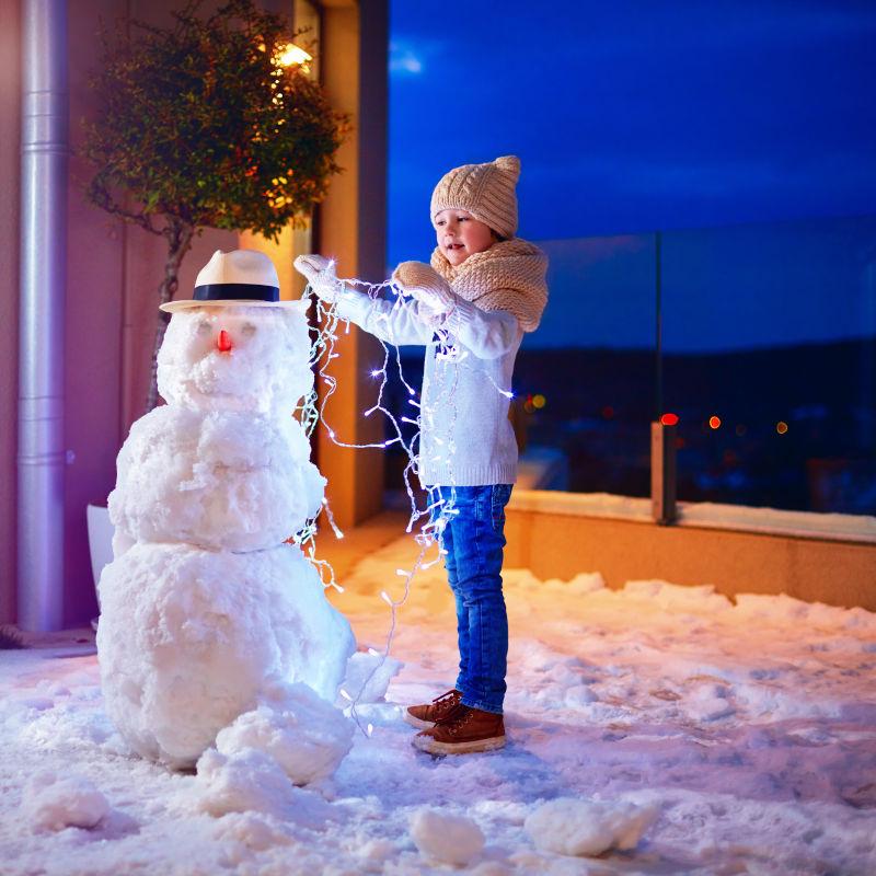 冬天正在堆雪人的小男孩