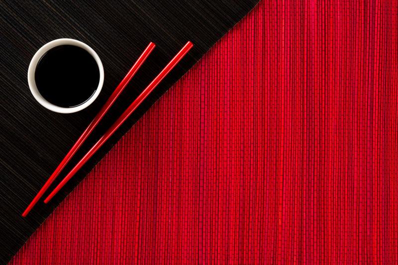 桌子上的酱油调料碗和红色筷子