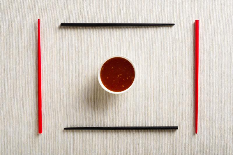 桌子上的调料碗和两双红黑色筷子