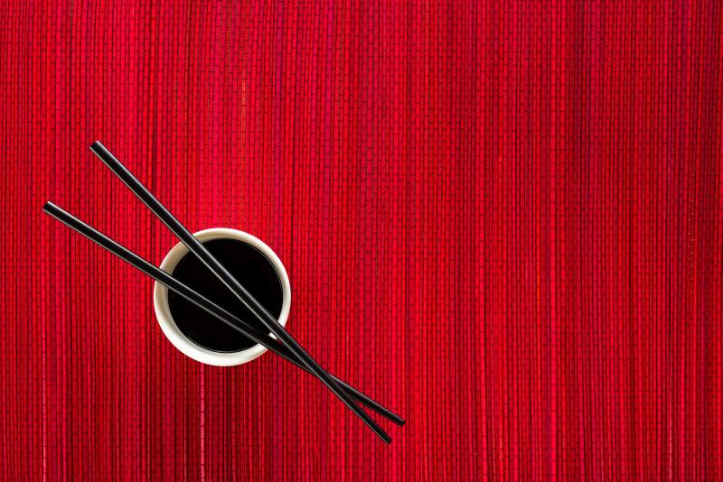 红色竹席面上的酱油碗和筷子