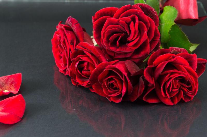 暗镜桌上的红玫瑰花束