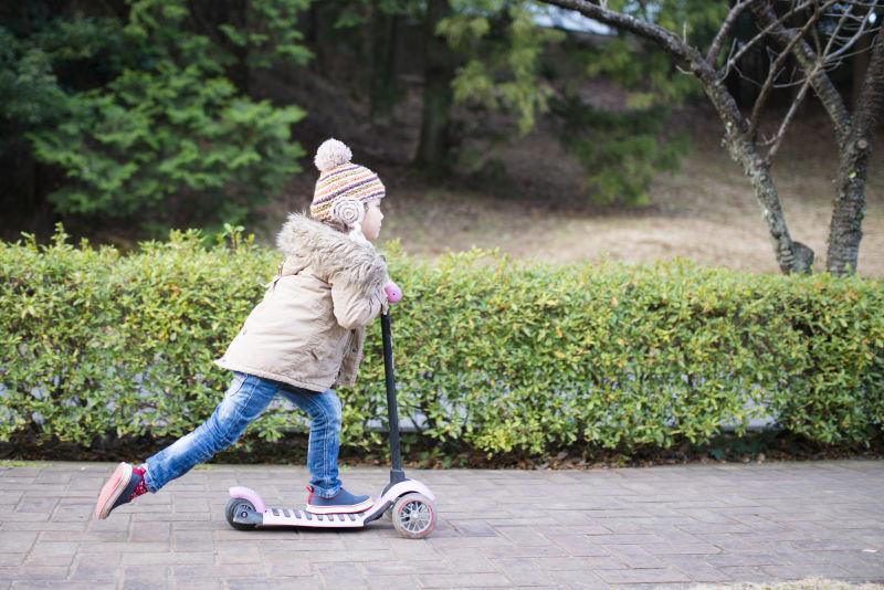 公园玩滑板车的小女孩